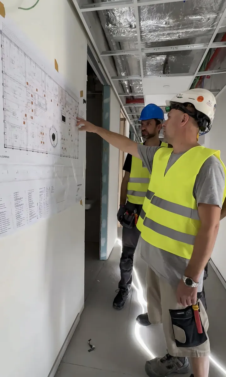 Werfoverleg bij een elektrisch plan aan de muur